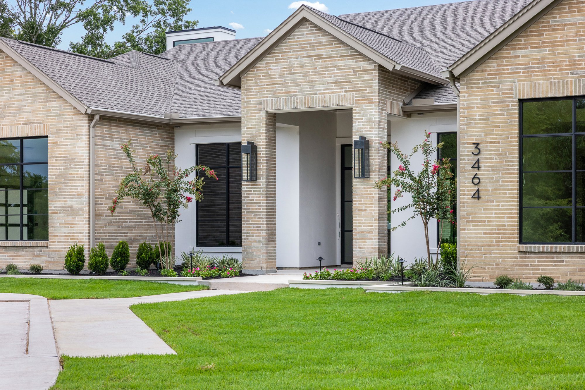 Covered front entrance with custom architecture and landscaping at a Traditions Club custom home