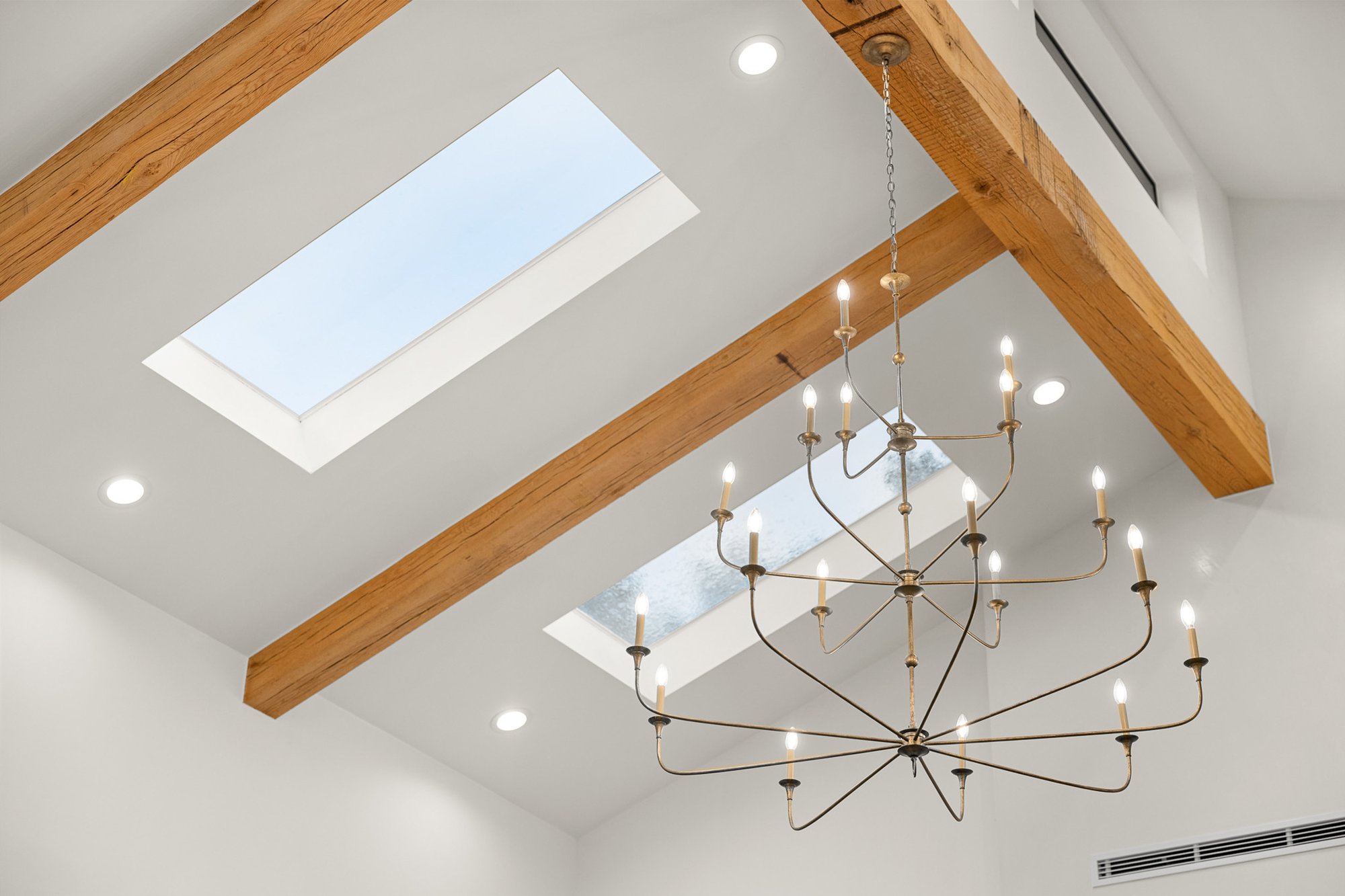 Custom plaster fireplace with reclaimed white oak ceiling beams in the main living room