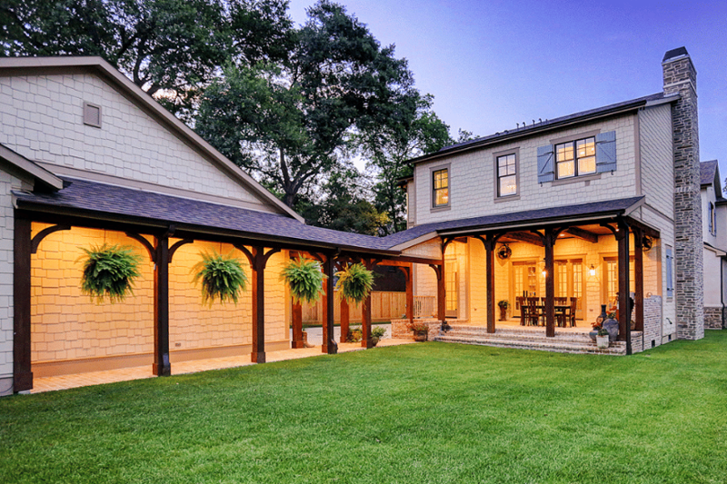 Exterior view of home with tan siding and pergola patio.