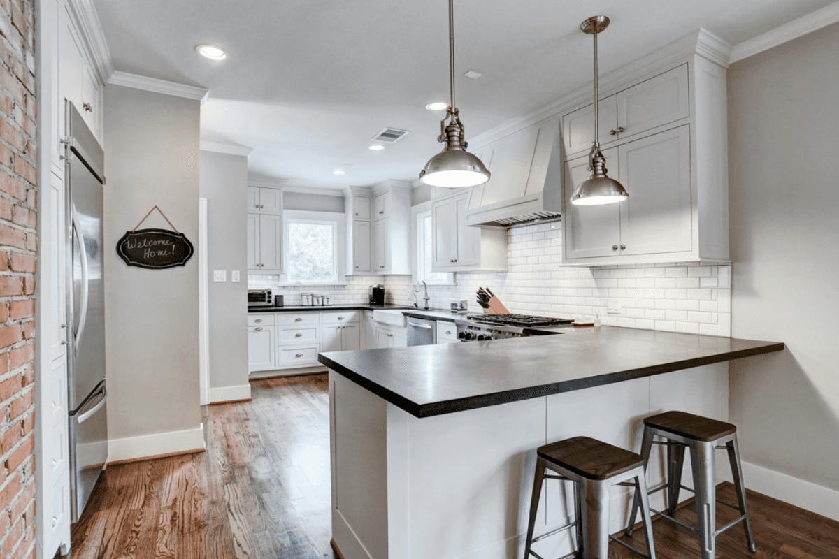 A Custom Home Kitchen with Two Bar Stools and Overhead Lighting