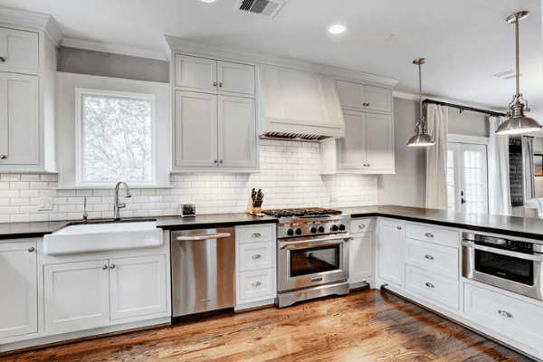 A Custom Kitchen with Wooden Floors, White Cabinets, and Black Countertops