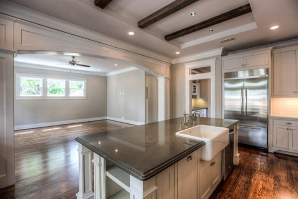 Farmhouse sink and exposed wood beams in a custom Houston kitchen