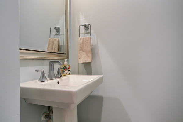 Custom Bathroom With A White Pedestal Sink and A Single Towel Rack