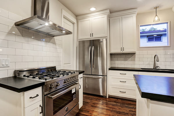 Custom Home Kitchen With Dark Wooden Floors And A Stainless Steal Refrigerator