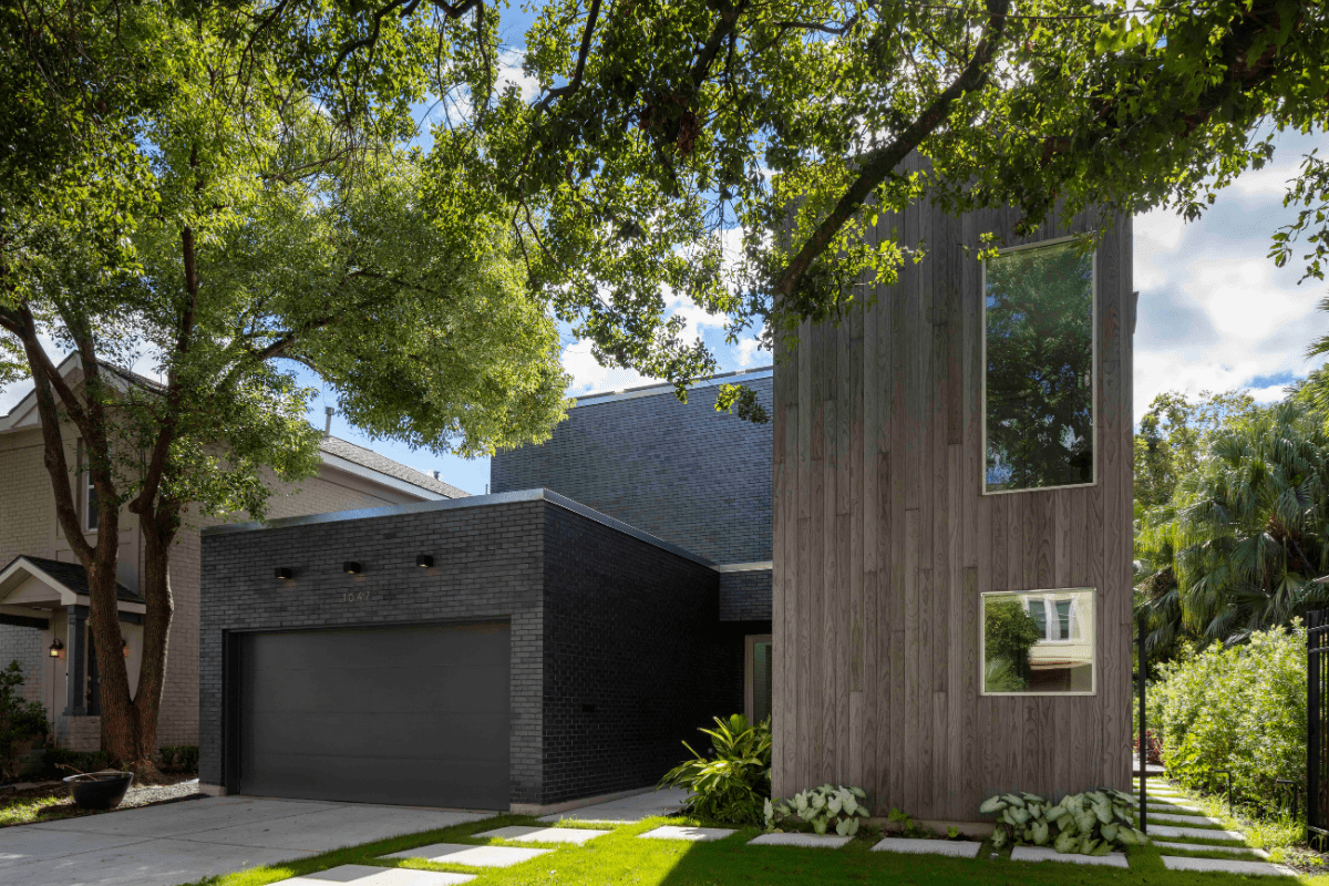 Exterior of Modern Rectangular Home Shrouded by Lush Green Trees in Yard Exterior of Modern Rectangular Home Shrouded by Lush Green Trees in Yard