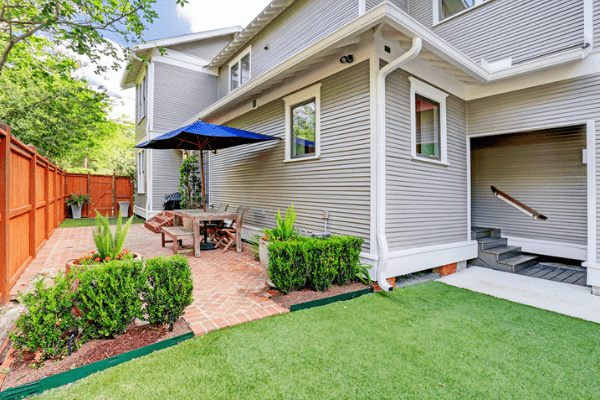 Custom Luxury Home Backyard with Green Grass and a Brick Deck